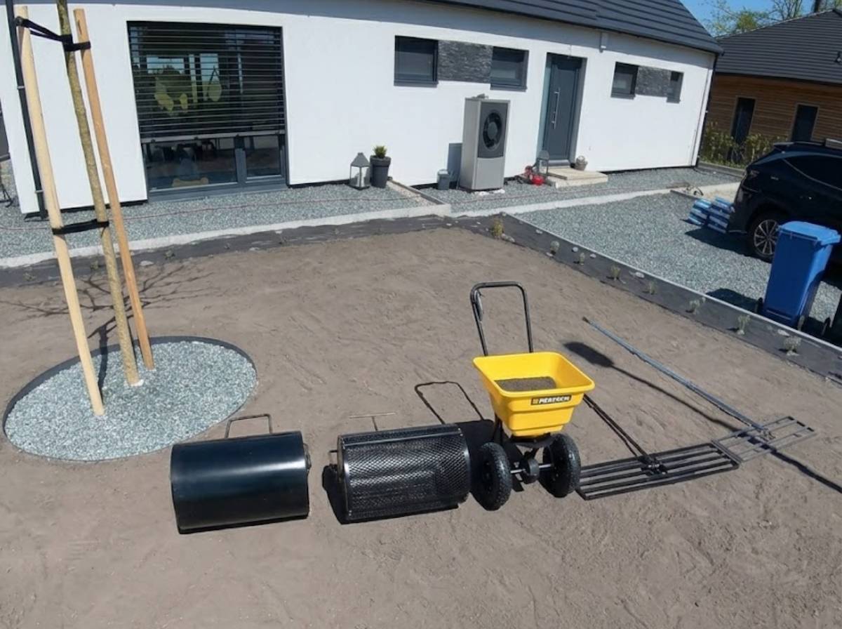 N&aacute;řad&iacute; na založen&iacute; tr&aacute;vn&iacute;ku &ndash; nivelačn&iacute; br&aacute;ny, v&aacute;lec na tr&aacute;vn&iacute;k, v&aacute;lec na substr&aacute;t a rozmetadlo osiva rozložen&eacute; na připraven&eacute; půdě před rodinn&yacute;m domem.